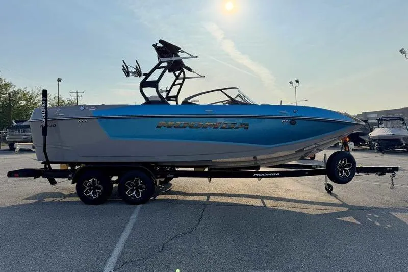 Slide: The Image of 2026 Moomba Mojo boat on trailer, blue and gray design, parked outdoors. - 6
