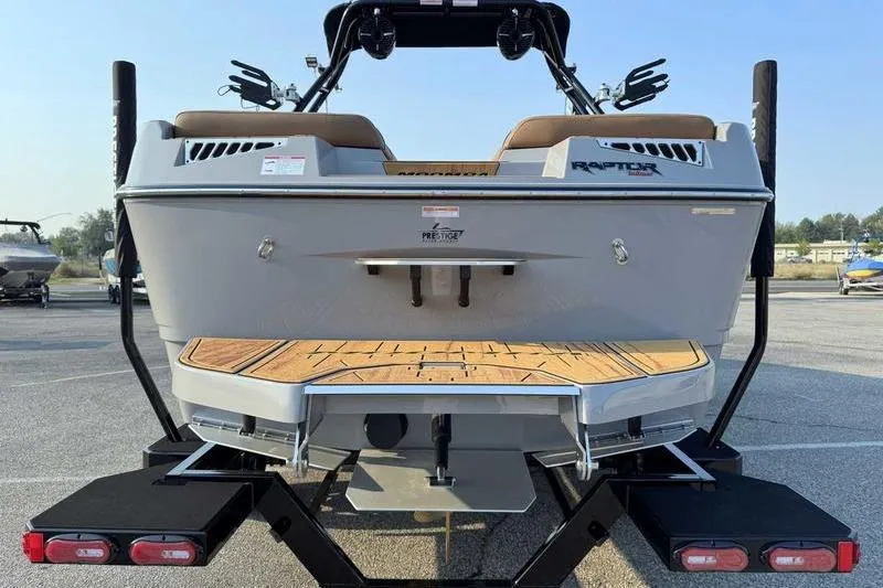 Slide: The Image of 2026 Moomba Mojo boat rear view on trailer, showcasing deck and seating. - 8
