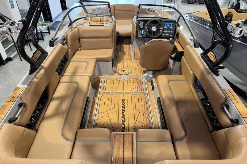 Slide: The Image of 2026 Moomba Mojo boat interior with tan seating and modern dashboard. - 9
