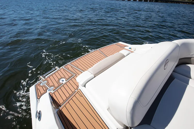 Slide: The Image of 2017 Crownline 285 SS boat with teak deck and white seating on water. - 11