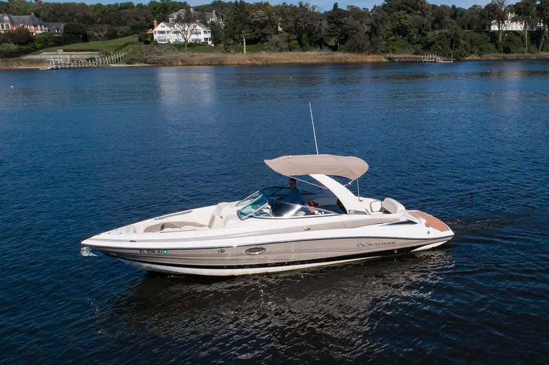 Slide: The Image of 2017 Crownline 285 SS boat cruising on a serene lake with scenic background. - 14