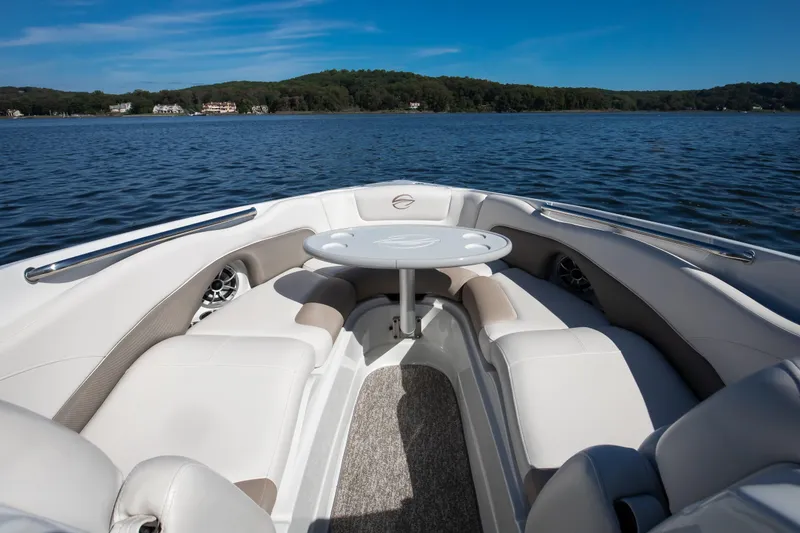 Slide: The Image of 2017 Crownline 285 SS boat interior with seating and table on a lake. - 3