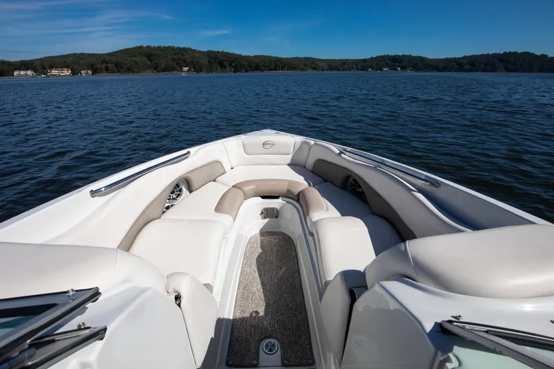 Slide: The Image of 2017 Crownline 285 SS boat interior with plush seating on a serene lake. - 4