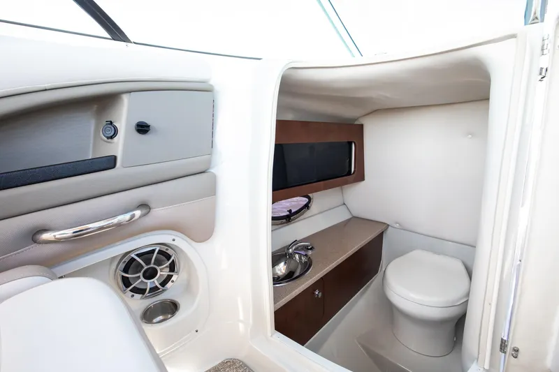 Slide: The Image of 2017 Crownline 285 SS boat interior with compact bathroom and modern amenities. - 6