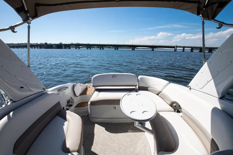 Slide: The Image of 2017 Crownline 285 SS boat interior with seating, table, and water view. - 8