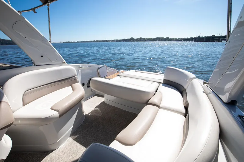 Slide: The Image of 2017 Crownline 285 SS boat interior with luxurious seating, overlooking a serene water view. - 9