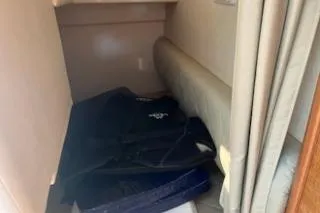 Slide: The Image of 2006 Sea Ray 260 Sundancer cabin interior with storage area and cushions. - 11