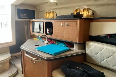 Slide: The Image of Interior of 2006 Sea Ray 260 Sundancer boat with kitchenette and seating area. - 14