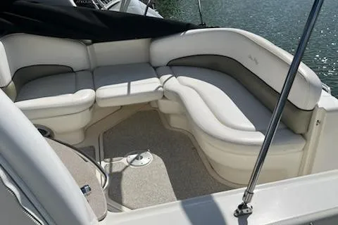 Slide: The Image of 2006 Sea Ray 260 Sundancer boat interior with white seating, docked by the water. - 18