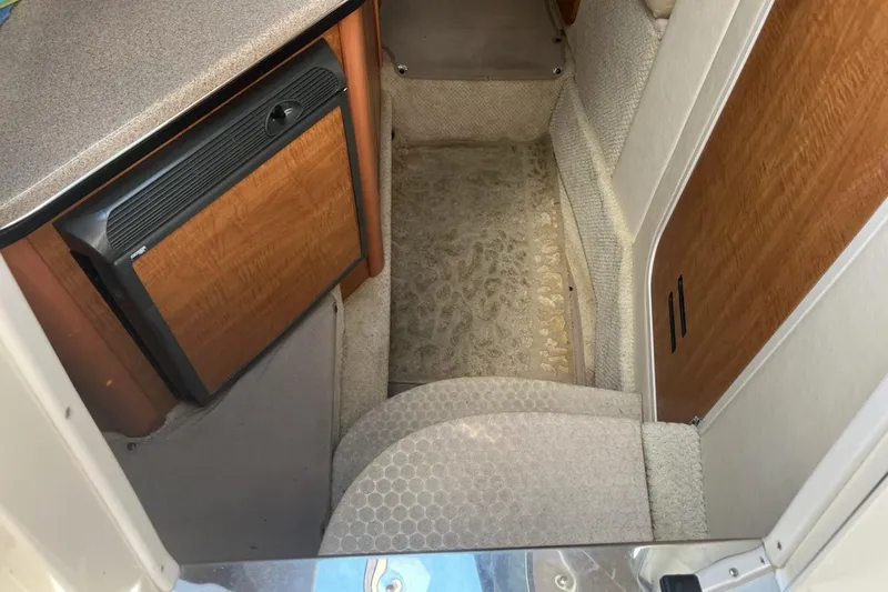 Slide: The Image of Interior of 2006 Sea Ray 260 Sundancer with compact kitchenette and carpeted flooring. - 8