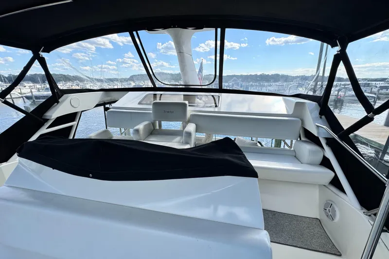 Slide: The Image of 1996 Silverton 372 Motor Yacht interior with marina view, featuring white seating and black canopy. - 20