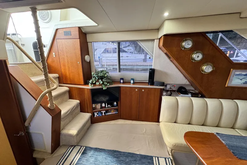 Slide: The Image of Interior of a 1996 Silverton 372 Motor Yacht with cozy seating and wooden cabinetry. - 23