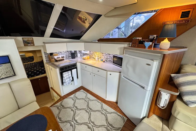 Slide: The Image of Interior of 1996 Silverton 372 Motor Yacht with modern kitchen and cozy seating area. - 25