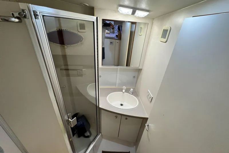 Slide: The Image of 1996 Silverton 372 Motor Yacht bathroom with shower, sink, and mirror. - 28