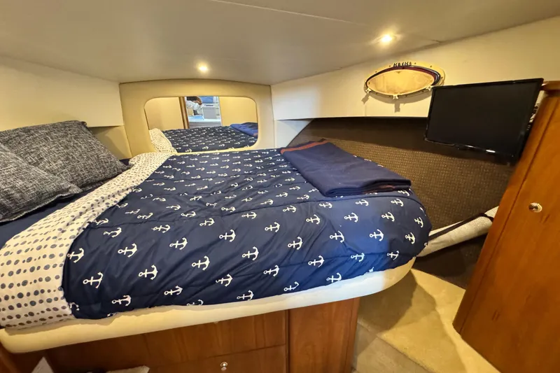 Slide: The Image of 1996 Silverton 372 Motor Yacht bedroom with nautical-themed bedding and wall-mounted TV. - 29