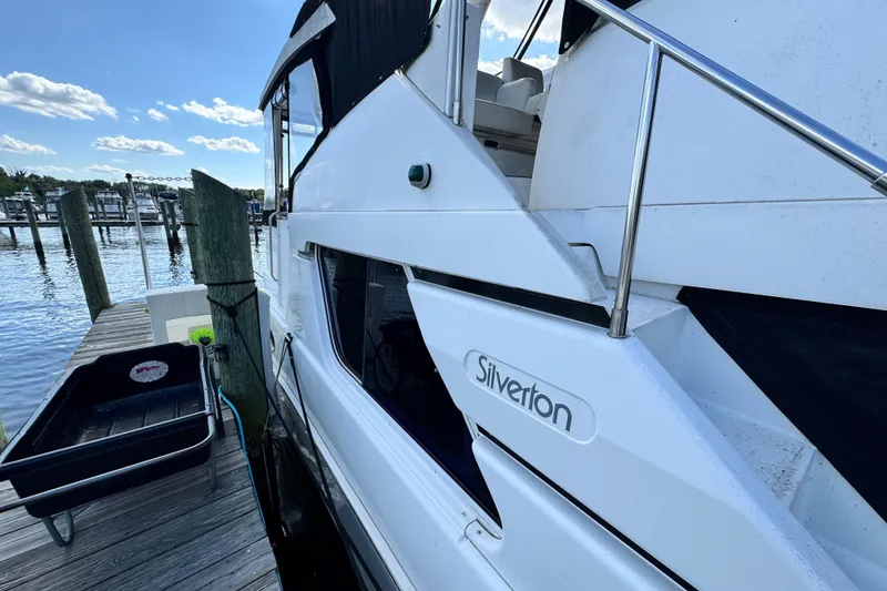 Slide: The Image of 1996 Silverton 372 Motor Yacht docked at marina, side view with clear sky. - 6