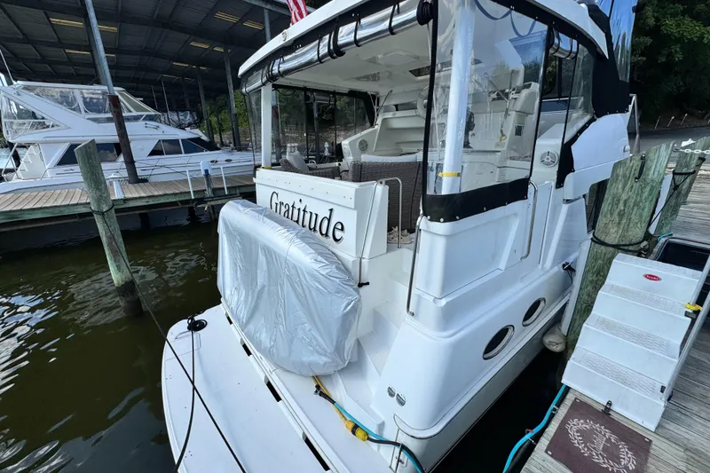 Slide: The Image of 1996 Silverton 372 Motor Yacht docked, rear view with covered seating area. - 7