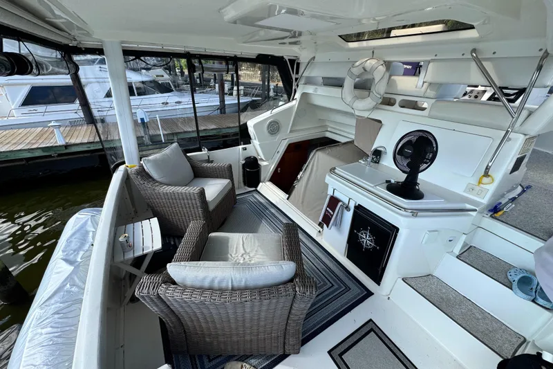 Slide: The Image of 1996 Silverton 372 Motor Yacht interior with wicker seating, fan, and nautical decor. - 8