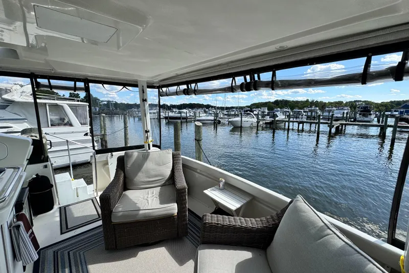 Slide: The Image of 1996 Silverton 372 Motor Yacht interior with marina view, featuring comfortable seating and open windows. - 9