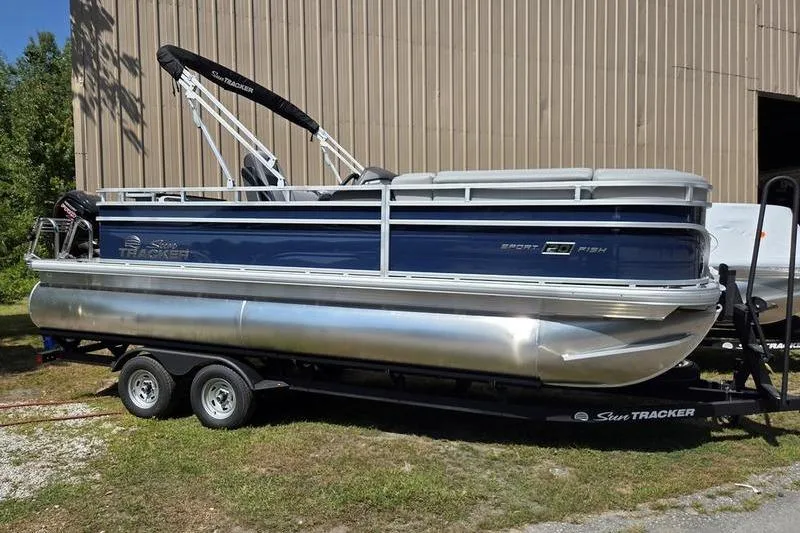 The Image of 2026 Sun Tracker SF 20 DLX pontoon boat on trailer, parked outdoors. - 1