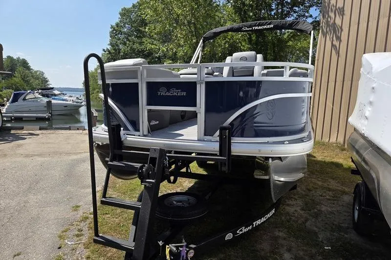 Slide: The Image of 2026 Sun Tracker SF 20 DLX pontoon boat on trailer near a lake. - 8