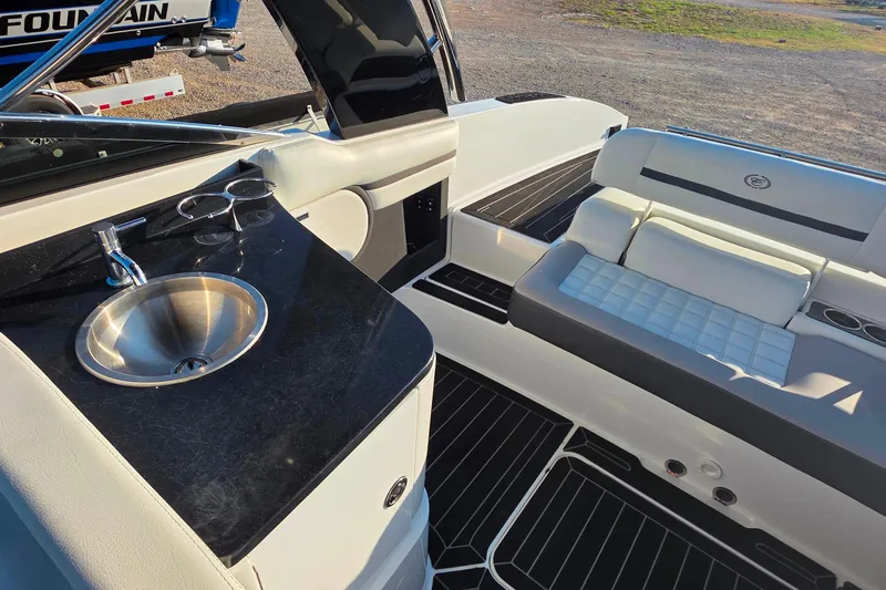 Slide: The Image of 2023 Cobalt R30 boat interior with sink, seating, and cup holders. - 26