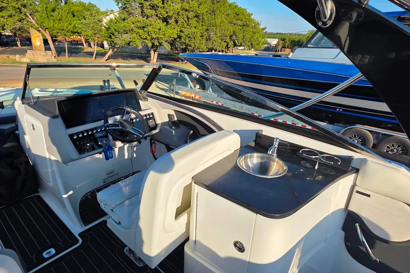 Slide: The Image of 2023 Cobalt R30 boat interior with helm, steering wheel, and sink. - 27