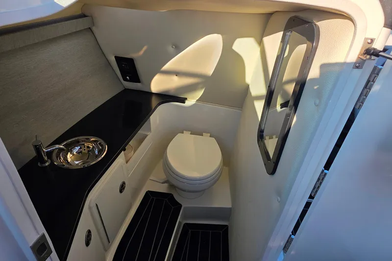 Slide: The Image of 2023 Cobalt R30 boat interior bathroom with sink, toilet, and mirror. - 38
