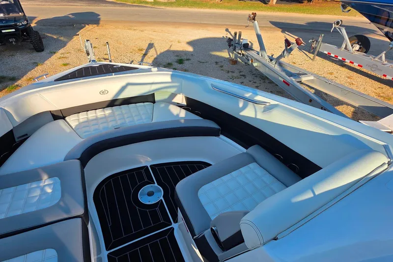 Slide: The Image of 2023 Cobalt R30 boat interior with white seating and black accents, parked on a trailer. - 43