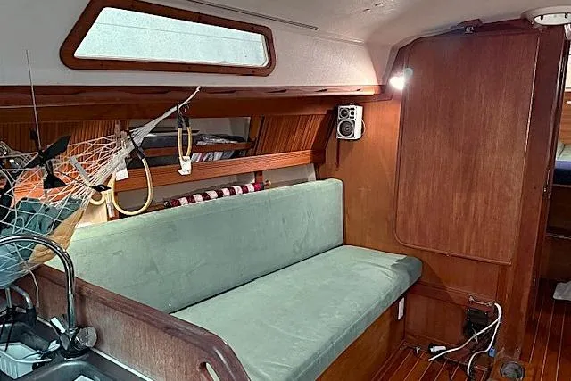 Slide: The Image of Interior of 1985 Sabre 36 sailboat with green sofa and wooden paneling. - 11