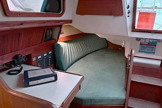 Slide: The Image of Interior of 1985 Sabre 36 sailboat with green cushioned seating and wooden accents. - 13