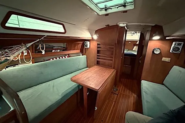 Slide: The Image of Interior of 1985 Sabre 36 sailboat with wooden furnishings and teal seating. - 9