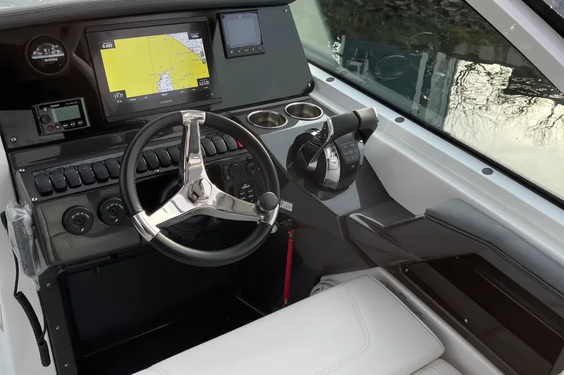 Slide: The Image of 2021 Blackfin 252DC boat dashboard with steering wheel, navigation screen, and controls. - 13