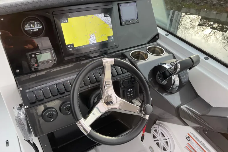 Slide: The Image of 2021 Blackfin 252DC boat dashboard with steering wheel, navigation screen, and controls. - 14