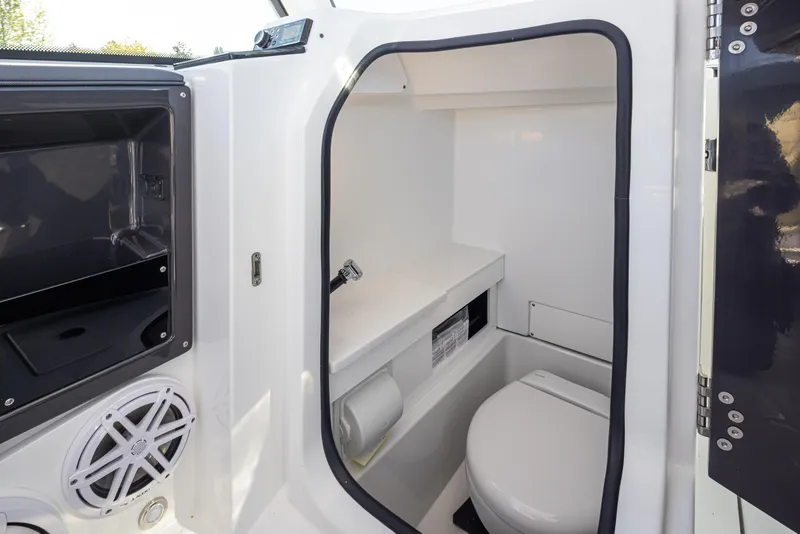 Slide: The Image of 2021 Blackfin 252DC boat interior with compact marine toilet and storage. - 17