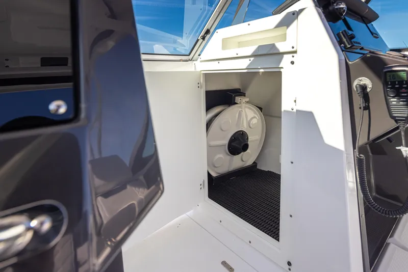 Slide: The Image of 2021 Blackfin 252DC boat interior storage compartment with coiled hose. - 18
