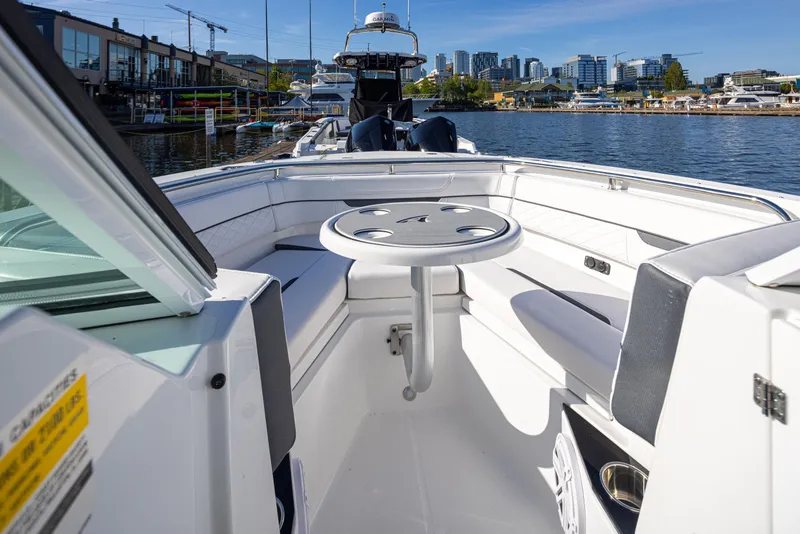 Slide: The Image of 2021 Blackfin 252DC boat interior with seating and table, docked in a marina. - 19