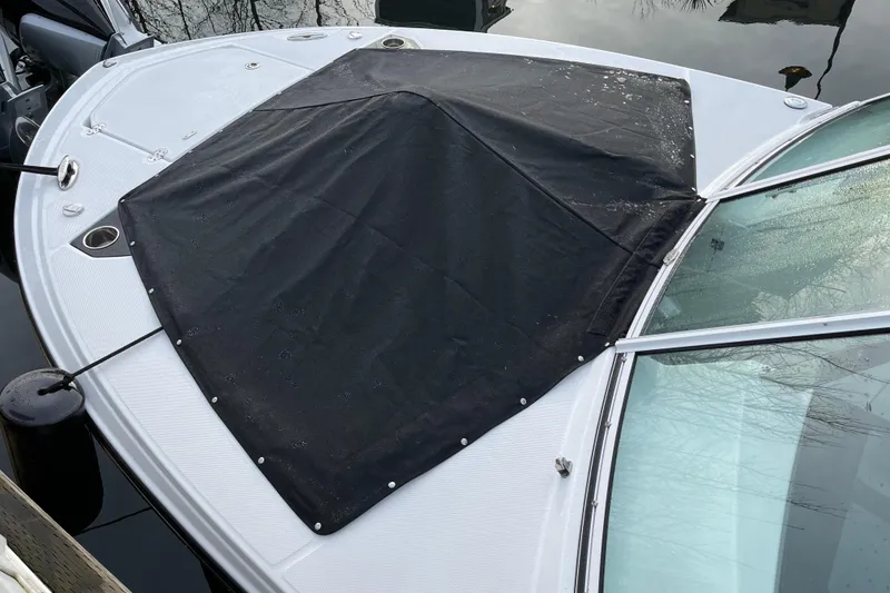 Slide: The Image of 2021 Blackfin 252DC boat with black cover on bow, docked on calm water. - 30