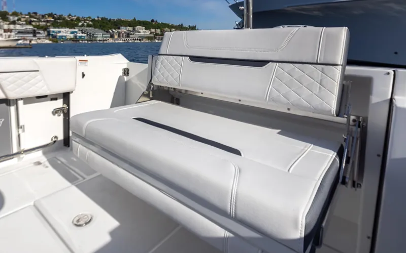 Slide: The Image of 2021 Blackfin 252DC boat interior with white cushioned seating, docked by the water. - 4