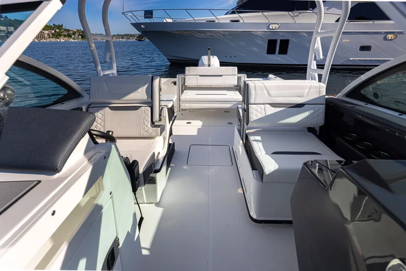 Slide: The Image of 2021 Blackfin 252DC boat interior with seating, on calm water, luxury yacht in background. - 9