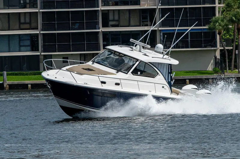 Slide: The Image of Pursuit boat cruising on water near modern buildings, creating a splash. - 24