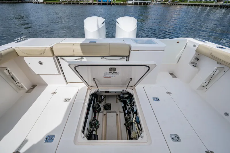 Slide: The Image of Open hatch on Pursuit boat deck revealing engine compartment by the water. - 27