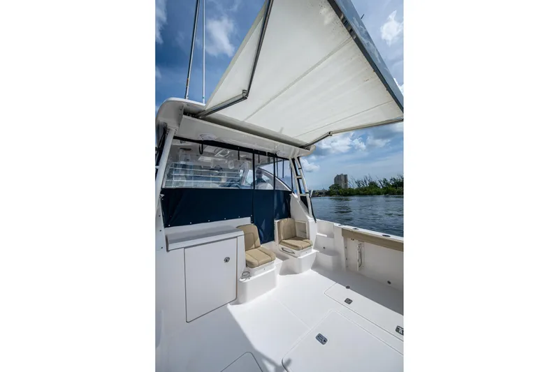 Slide: The Image of Pursuit boat interior with seating, canopy, and water view under a blue sky. - 31