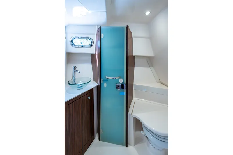 Slide: The Image of Modern boat bathroom with glass sink, frosted door, and wooden cabinetry by Pursuit. - 34