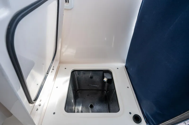 Slide: The Image of Open storage compartment on a Pursuit boat with a dark interior and white exterior. - 37