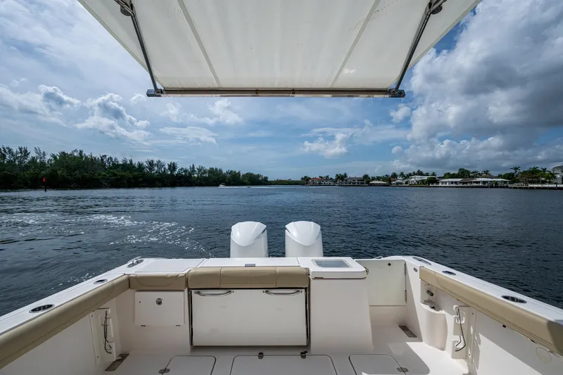 Slide: The Image of Pursuit boat deck with canopy, overlooking serene water and distant shoreline. - 39