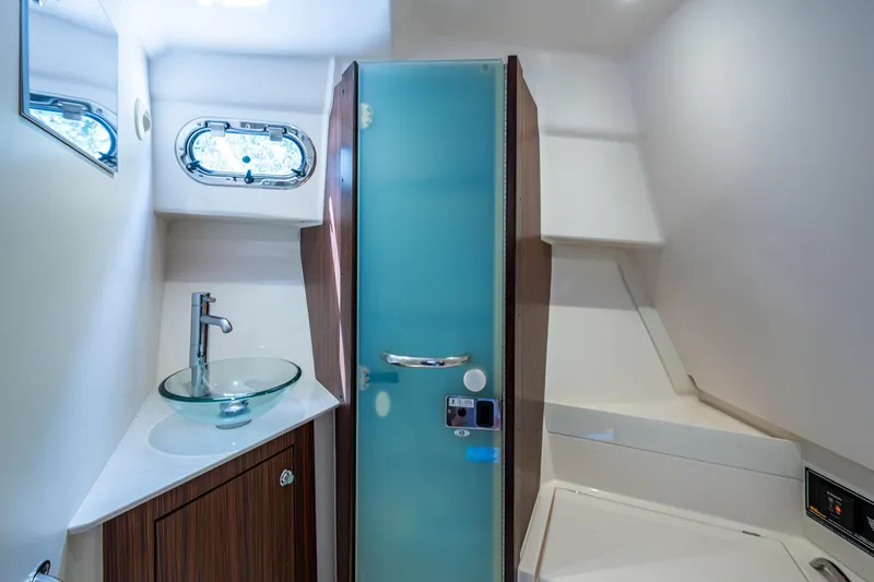 Slide: The Image of Modern boat bathroom with glass sink, frosted door, and porthole window by Pursuit. - 40