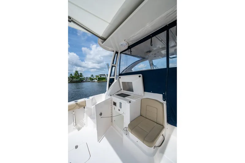 Slide: The Image of Interior view of a Pursuit boat with seating and storage, overlooking a scenic waterfront. - 44