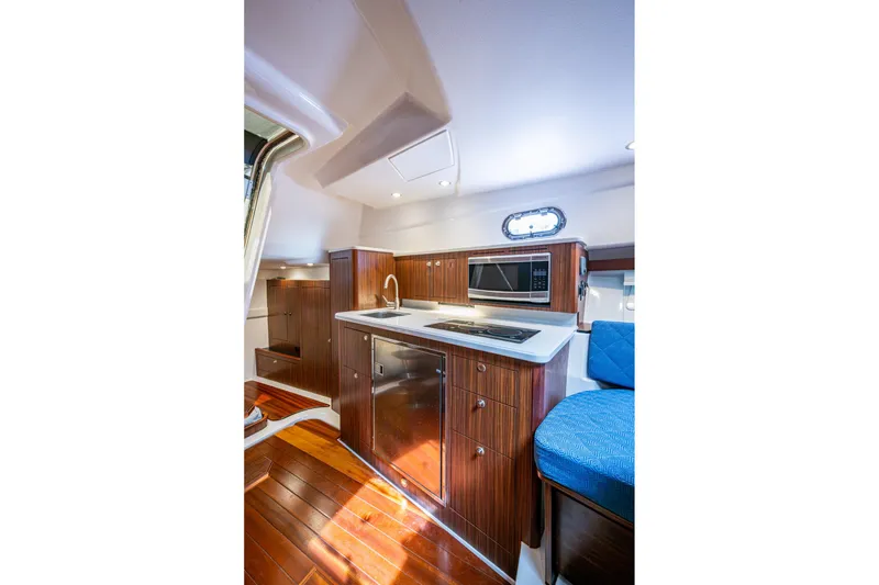 Slide: The Image of Luxurious Pursuit yacht interior kitchen with wood cabinetry, modern appliances, and elegant design. - 45
