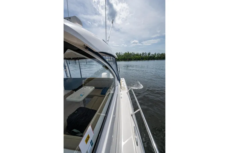 Slide: The Image of Side view of a Pursuit boat cruising on a calm river under a cloudy sky. - 53